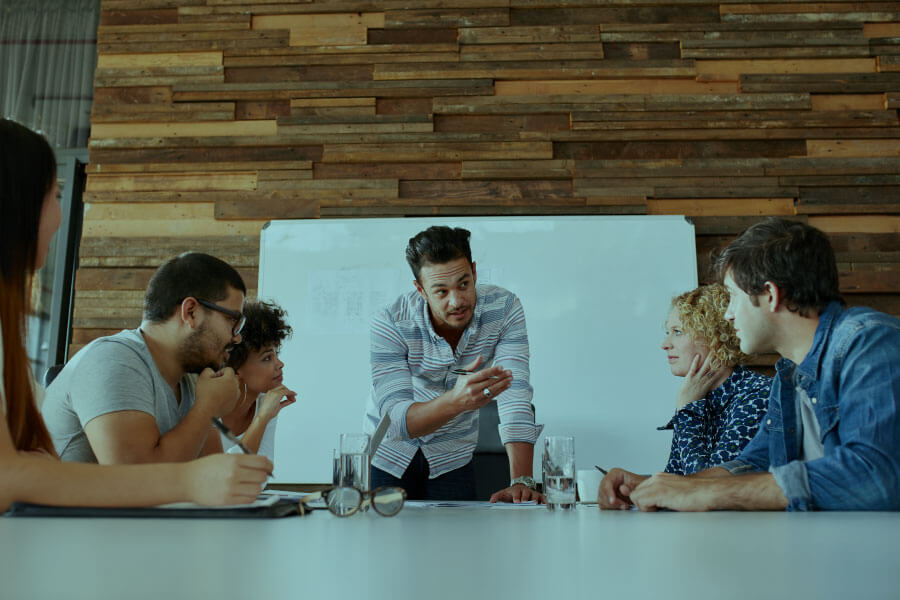 man at a table presenting to a group