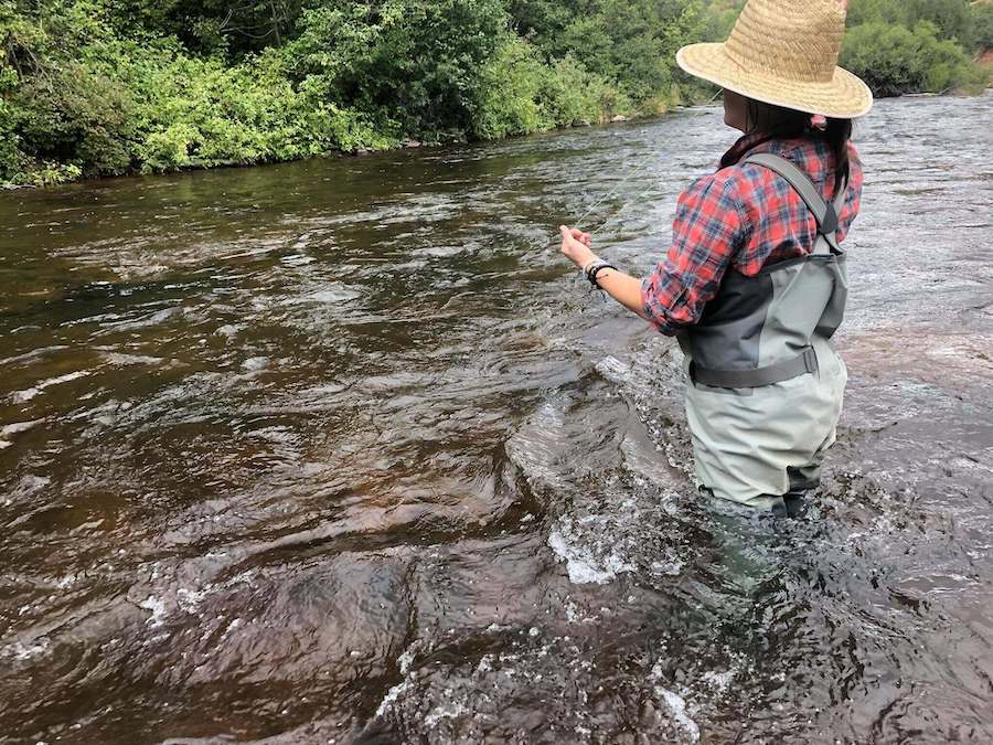 woman fishing in stream